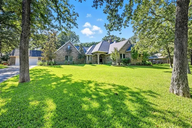 a view of a house with a yard and tree s