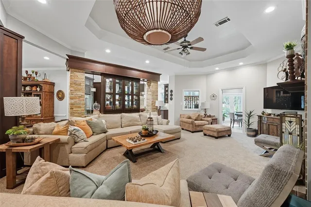 a living room with furniture a chandelier and a flat screen tv