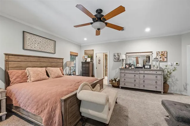 a bedroom with a bed a couch and a ceiling fan