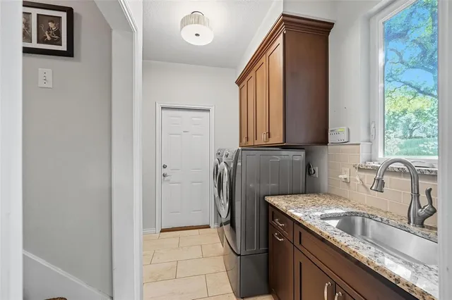 a kitchen with stainless steel appliances granite countertop a sink and a refrigerator