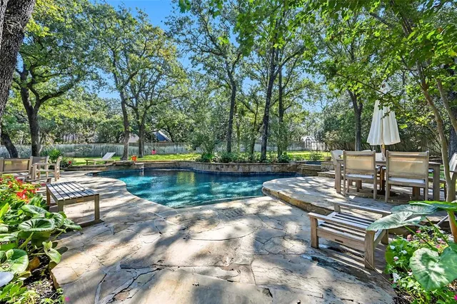 a view of a lake with chairs and trees