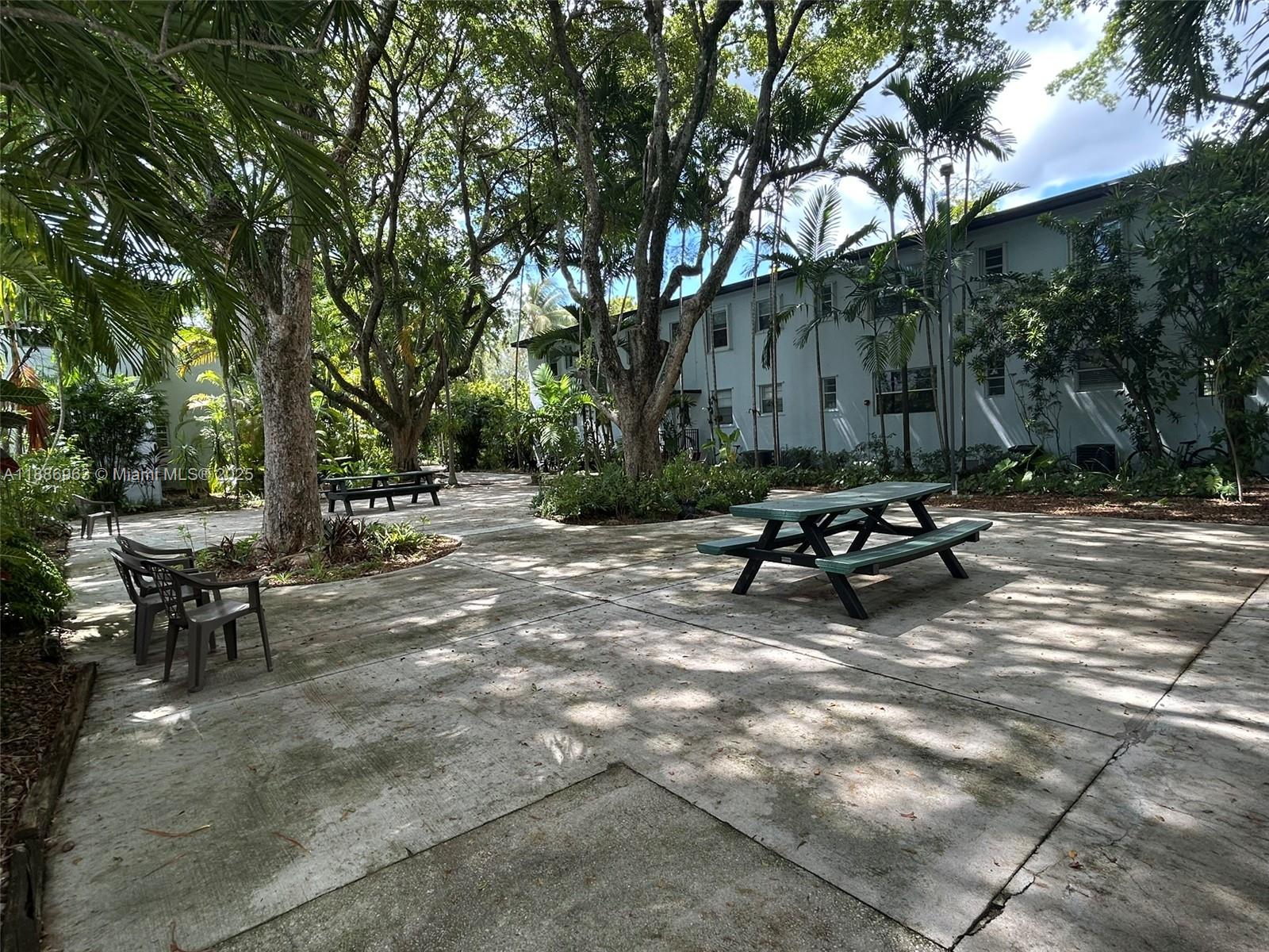7865 Southwest 57th Avenue, Unit 47C Miami, FL 33143 - Photo 18 of 20 a view of backyard with table and chairs and a large tree
