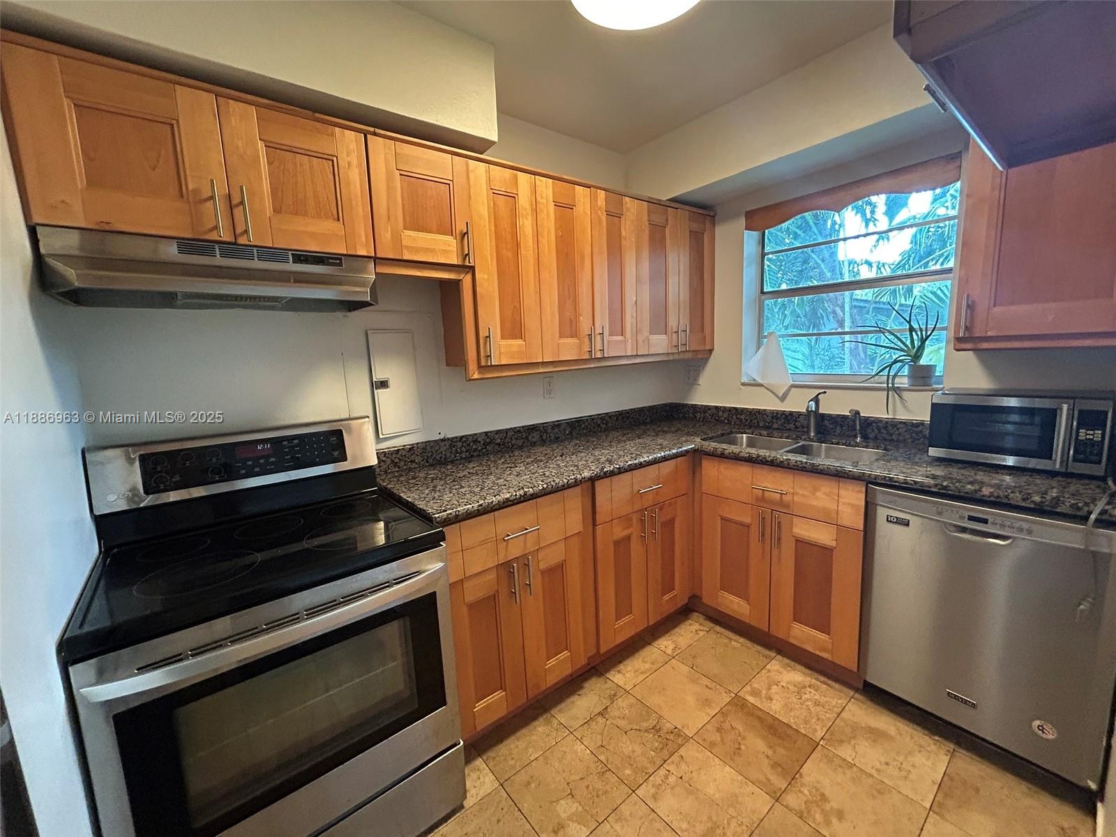 7865 Southwest 57th Avenue, Unit 47C Miami, FL 33143 - Photo 7 of 20 a kitchen with granite countertop cabinets stainless steel appliances and a window
