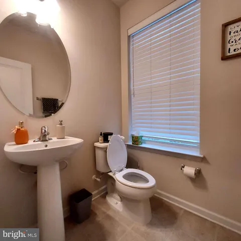 a bathroom with a sink a toilet and mirror