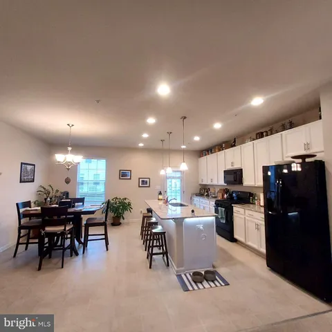 a kitchen with a dining table chairs and stainless steel appliances