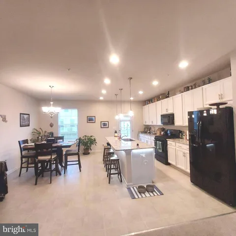 a kitchen with a dining table chairs and a refrigerator