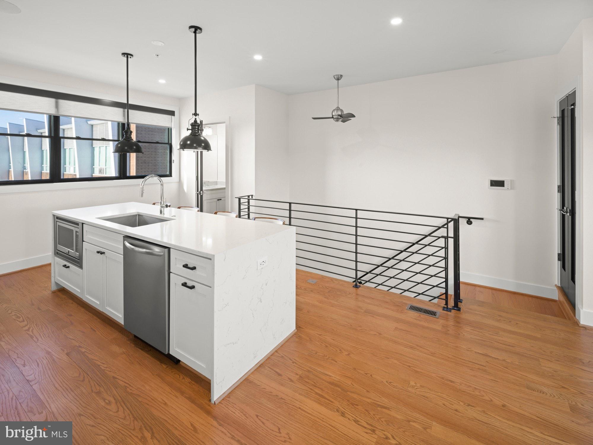 609 Gresham Place Northwest, Unit 2 Washington, DC 20001 - Photo 18 of 35 a kitchen with stainless steel appliances granite countertop a sink a stove and a wooden floors