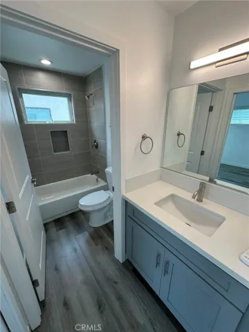 a bathroom with a double vanity sink toilet mirror and bathtub
