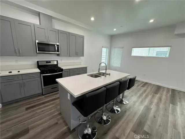 a kitchen with a sink refrigerator and cabinets