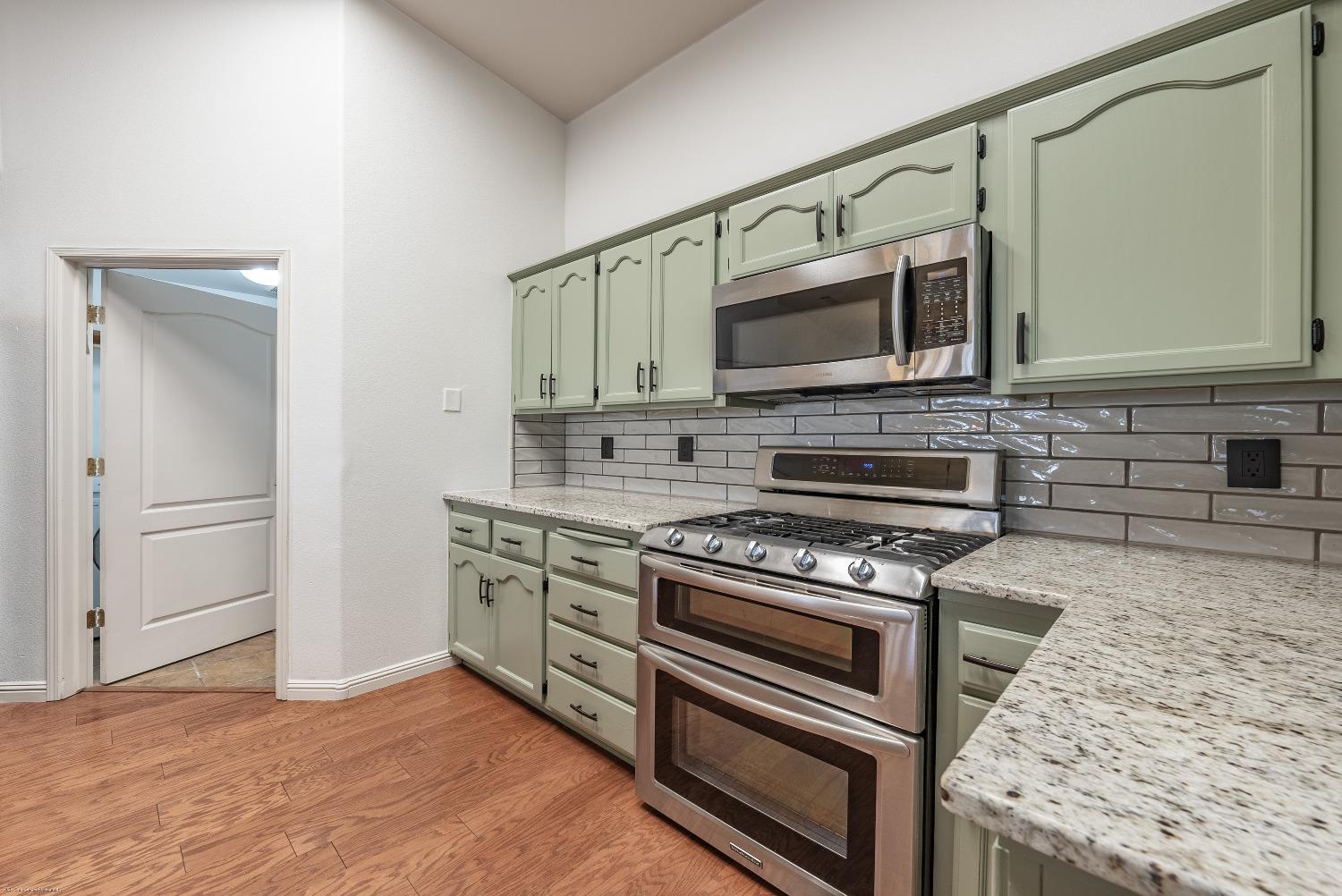 695 Crescent Lane Lemoore, CA 93245 - Photo 11 of 47 a kitchen with a stove and a microwave