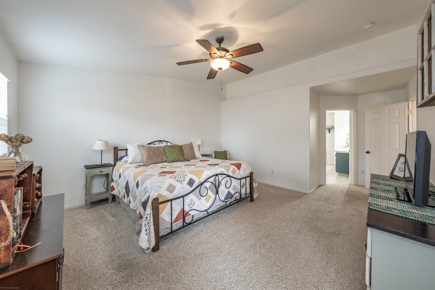 695 Crescent Lane Lemoore, CA 93245 - Photo 23 of 47 a bedroom with a bed and a chandelier