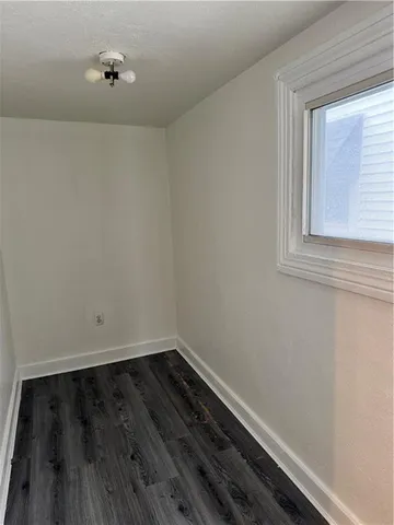 a view of a small space with wooden floor and a window