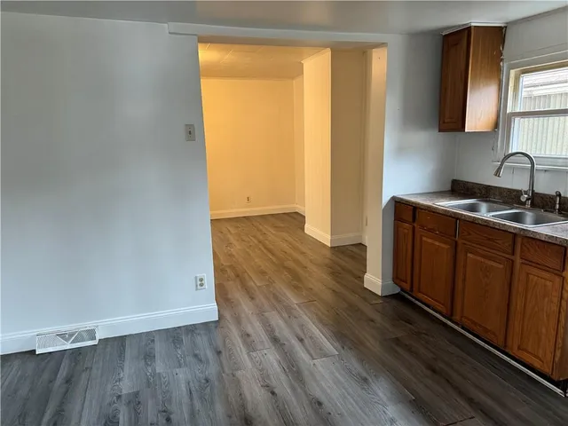 a view of a kitchen with wooden floor and a sink