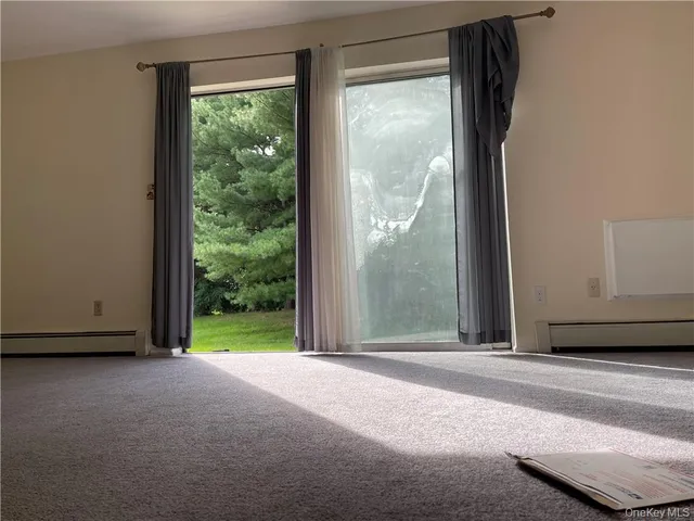 a view of a room with large windows and a small yard