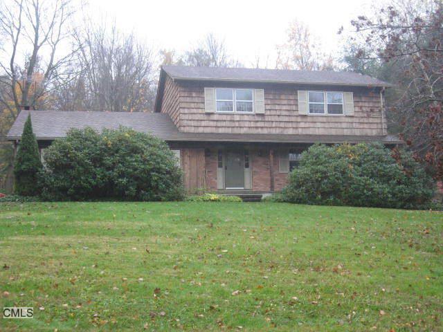 a brick house with a yard and a tree