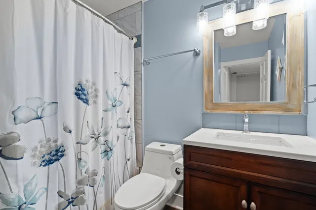 a bathroom with a sink a toilet and shower curtain
