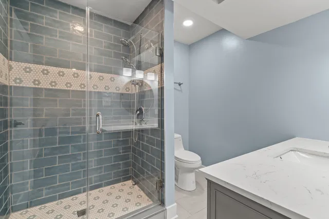 a bathroom with a sink a toilet and shower