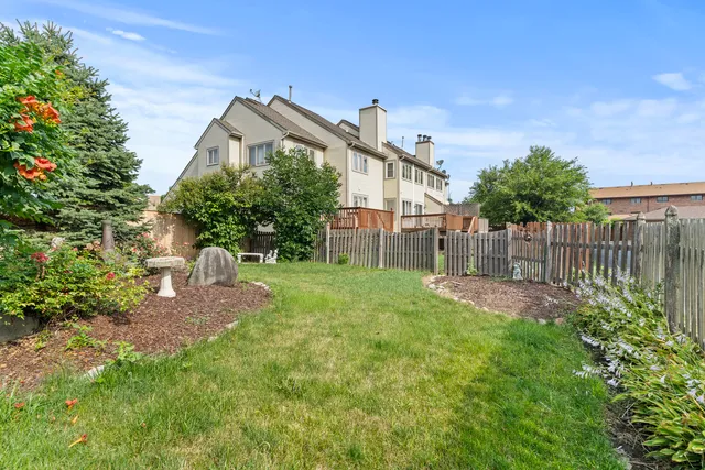 a view of a house with a yard and wooden fence