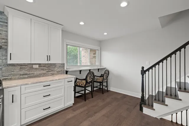 a kitchen with granite countertop white cabinets and white appliances