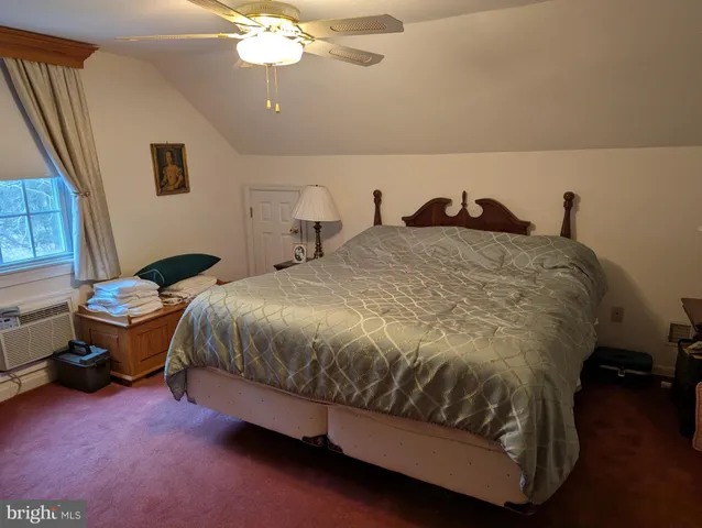 a spacious bedroom with a bed and a chandelier