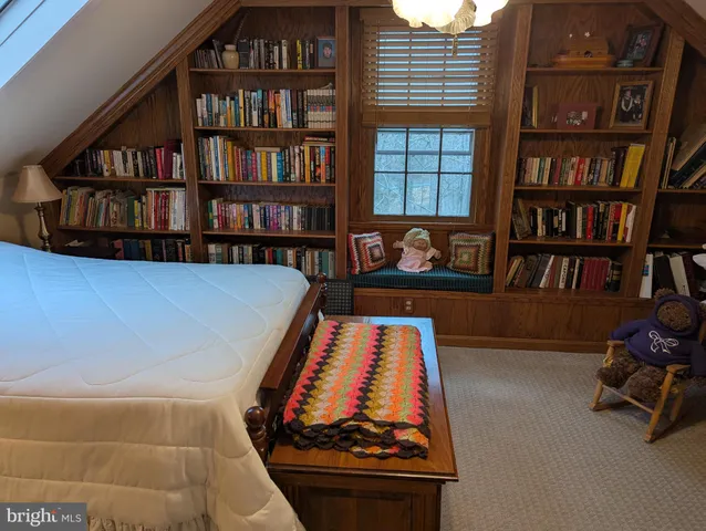 a living room with furniture and a book shelf
