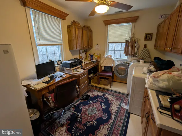 a view of a workspace with furniture and a window