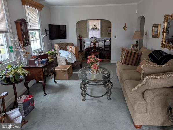 a living room with furniture a flat screen tv and a window