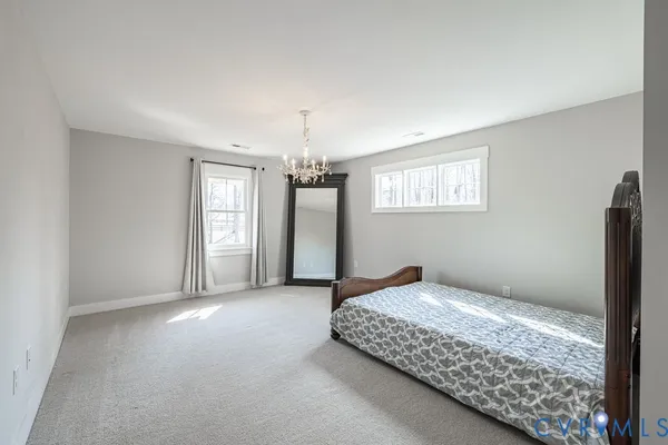 a spacious bedroom with a bed and a chandelier