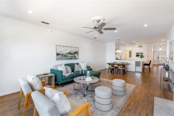 a kitchen with stainless steel appliances kitchen island granite countertop a sink a stove and a wooden floors