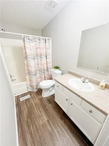 a bathroom with a double vanity sink toilet and a tub