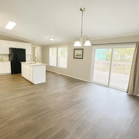 a view of a kitchen with wooden floor and a window