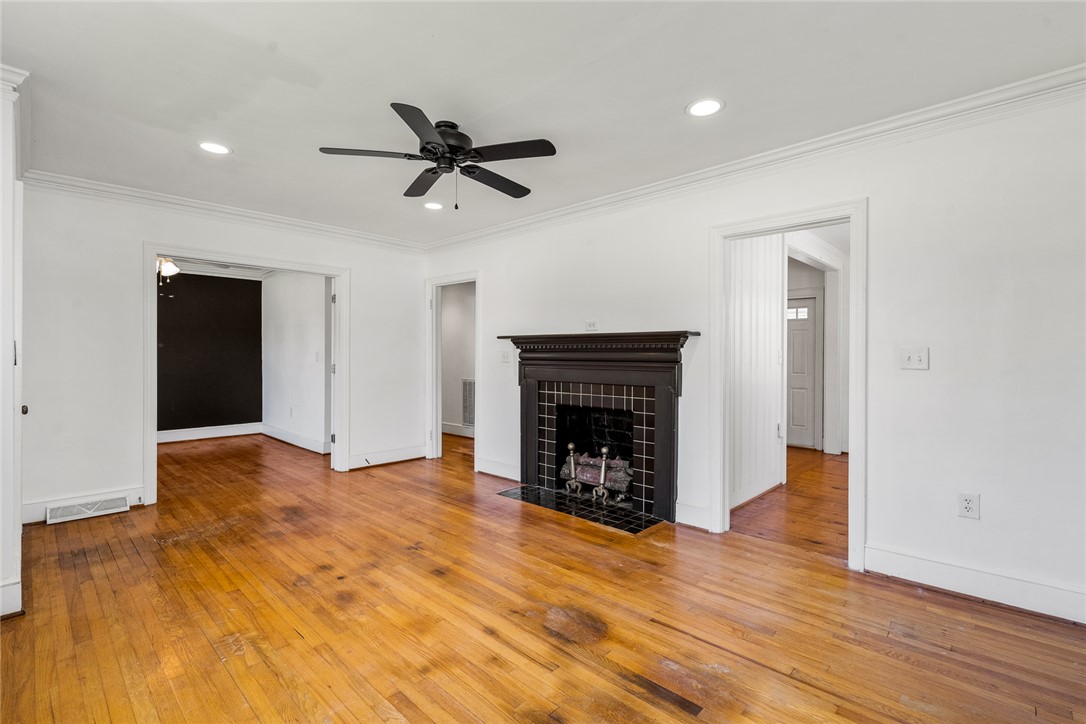 419 Whitehall Road Anderson, SC 29625 - Photo 4 of 28 A classic fireplace grounds this generously proportioned living area, featuring warm hardwood floors and a ceiling fan for comfort.