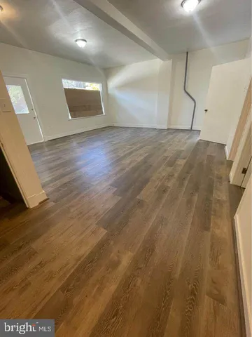 a view of a room with wooden floor and entryway