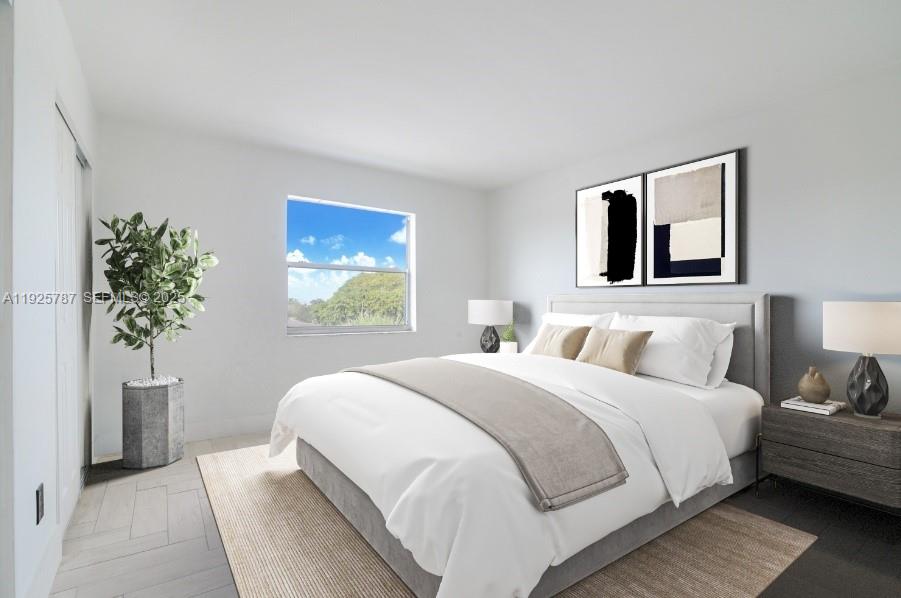 12215 West Dixie Highway, Unit 306 North Miami, FL 33161 - Photo 2 of 7 a bedroom with a large bed and a potted plant