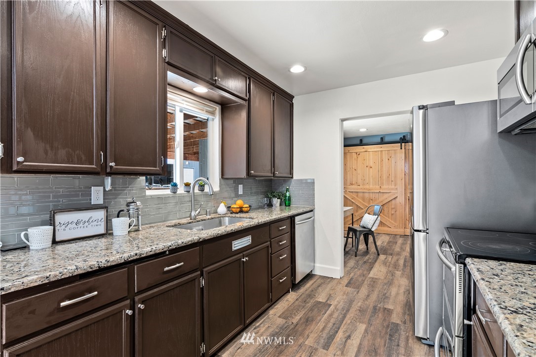 7404 Golden Given Road East Tacoma, WA 98404 - Photo 7 of 23 a kitchen with granite countertop a sink stove and cabinets