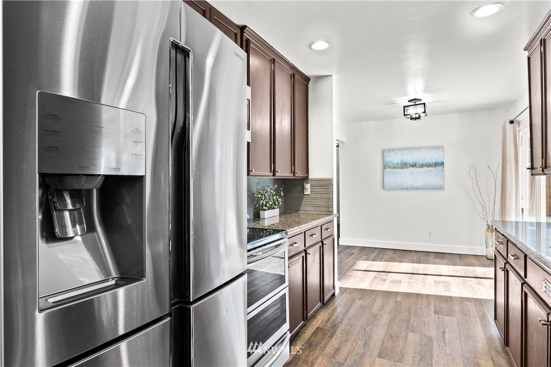 7404 Golden Given Road East Tacoma, WA 98404 - Photo 9 of 23 a view of a refrigerator in kitchen and wooden floor