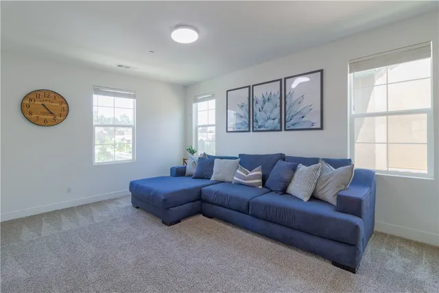 a view of a patio with table and chairs potted plants and floor to ceiling window