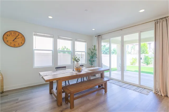 a kitchen with stainless steel appliances a table chairs and a refrigerator