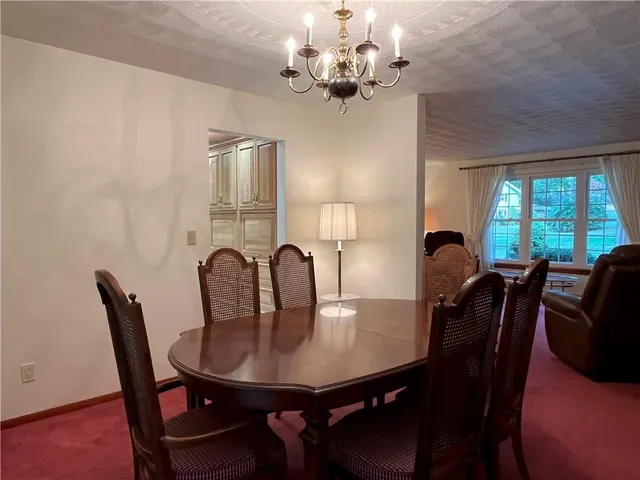 a view of a dining room with furniture and chandelier