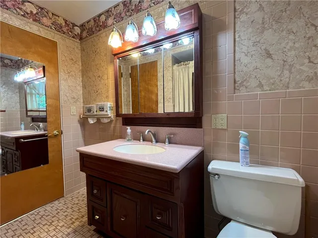 a bathroom with a sink a toilet and a mirror