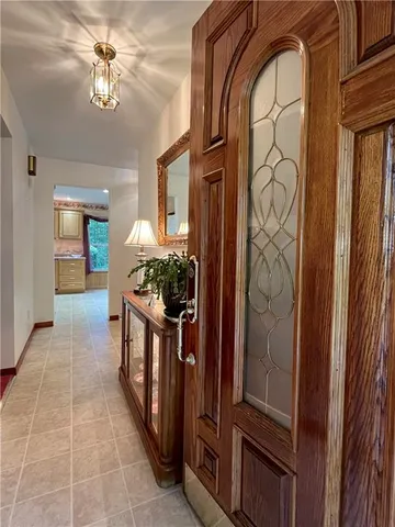 a hallway with painting and a chandelier