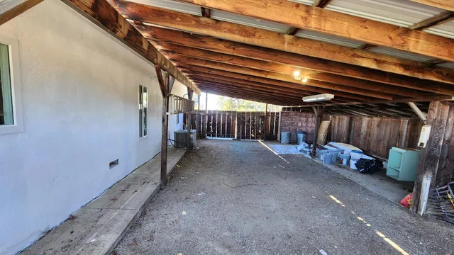 a view of a hallway with wooden floor and a living room