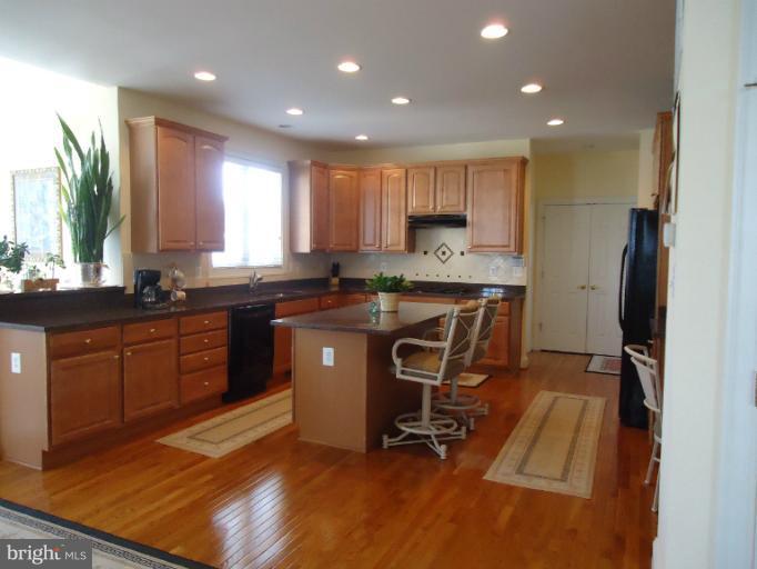 8919 Ricky Trevor Road Perry Hall, MD 21128 - Photo 1 of 27 a kitchen with stainless steel appliances granite countertop a sink a stove a refrigerator cabinets and dining table