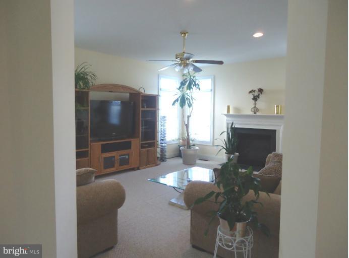 8919 Ricky Trevor Road Perry Hall, MD 21128 - Photo 22 of 27 a living room with furniture a chandelier and a fireplace