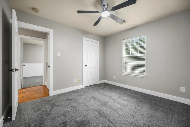 an empty room with fan and windows