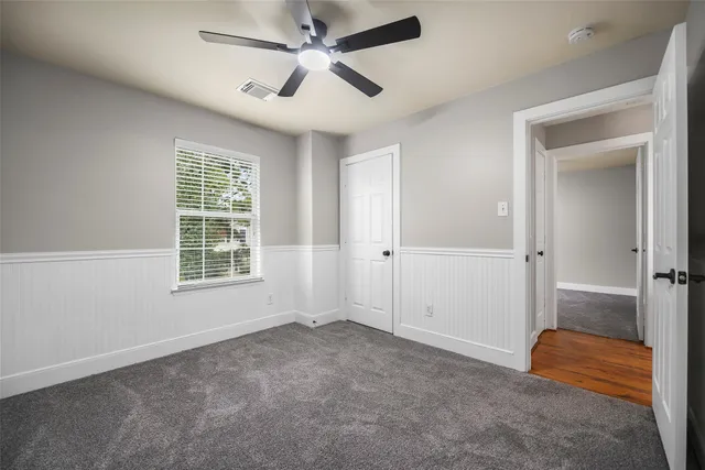 an empty room with fan and windows