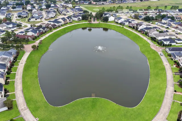an aerial view of a swimming pool with a yard and lake view