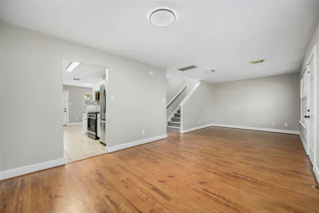 a view of empty room with wooden floor