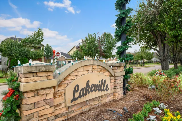 a view of a sign board with large trees
