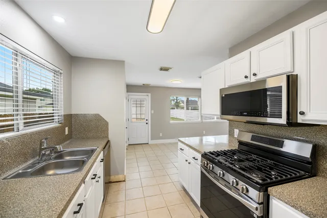 a kitchen with a stove a sink and a microwave
